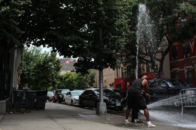 A photo of someone opening up a fire hydrant in East Harlem